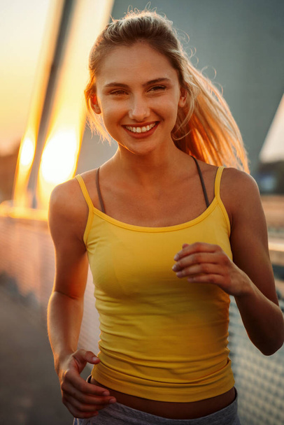Portrait of fit and sporty young woman exercising in city. People sport exercise urban healthy lifestyle concept - Φωτογραφία, εικόνα