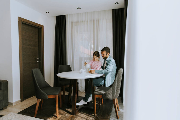 Isä ja tytär juomassa teetä yhdessä olohuoneessa - Valokuva, kuva
