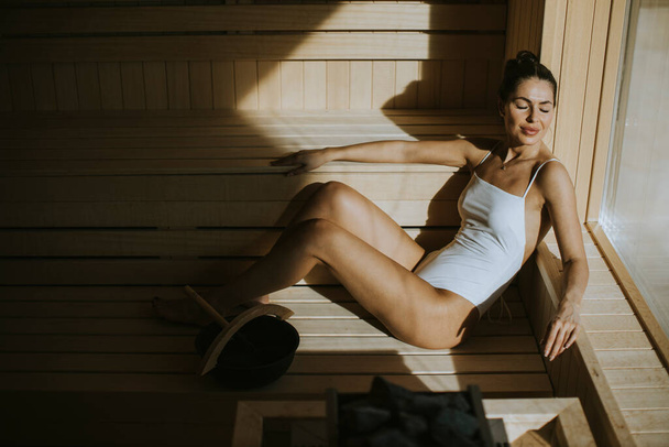 Attractive young woman relaxing in the sauna - Foto, Imagen