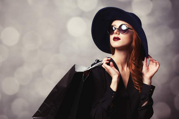 Style redhead girl with sunglasses and shopping bags. - Photo, Image