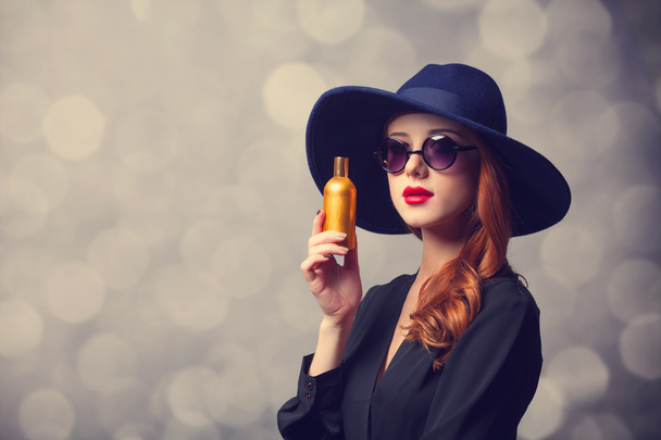 Styl rusovláska dívka v klobouku drží parfém - Fotografie, Obrázek