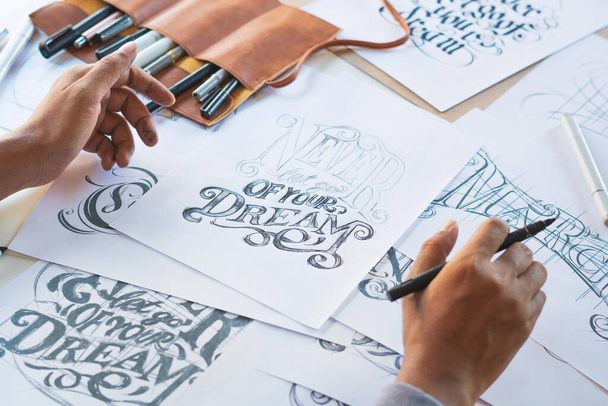 Tipográfia Kalligráfia művész tervező rajz vázlat írja hagyta betűzött toll ecset tinta papír asztali műalkotás.Munkahelyi design stúdió. - Fotó, kép