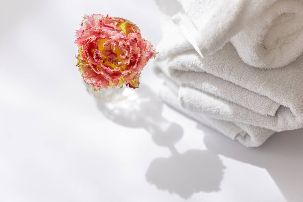 Primer plano, toallas de baño de rizo blanco y una flor. - Foto, Imagen