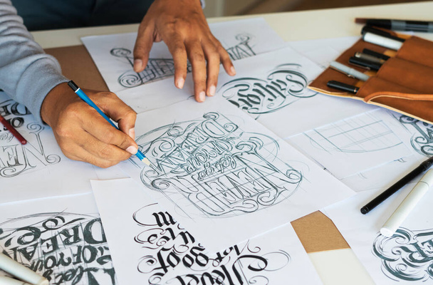 Typography Calligraphy artist designer drawing sketch writes letting spelled pen brush ink paper table artwork.Workplace design studio. - Фото, изображение