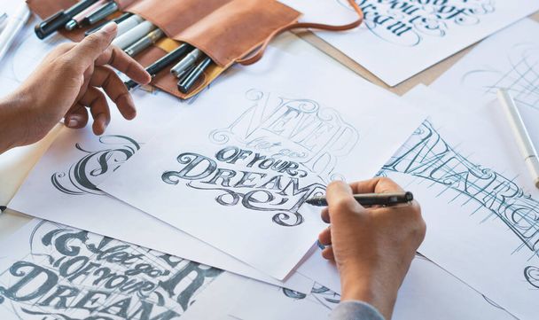 Typography Calligraphy artist designer drawing sketch writes letting spelled pen brush ink paper table artwork.Workplace design studio. - Foto, Imagen