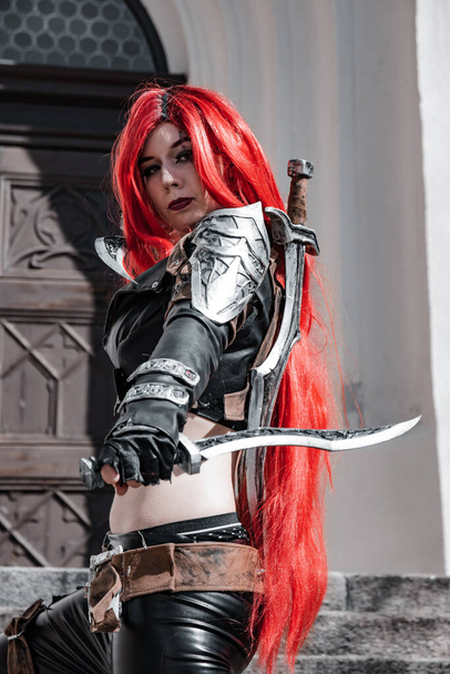 a woman with red hairs as a warrior with a dagger in her hand - Photo, Image
