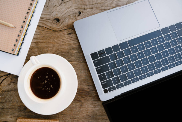 Photo of laptop and coffee cup on wooden desk outdoors - Фото, зображення