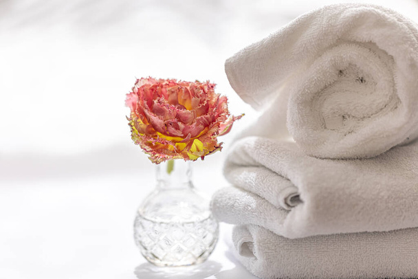 Gros plan, serviettes de bain en éponge blanche et une fleur. - Photo, image