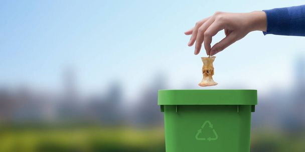 Woman putting biodegradable organic waste in a bin, recycling and waste segregation concept - Foto, immagini