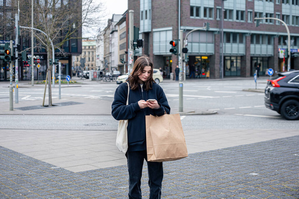 A young woman in the city on the street with a package, shopping concept. - Photo, Image