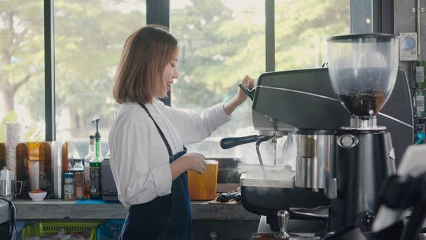Young woman barista wearing aprons working at the counter at the cafe coffee shop, Owner small business concept - 写真・画像