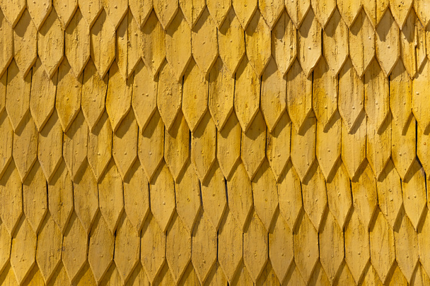 Ornament aus gelbem Holzdach bei Tag  - Foto, Bild