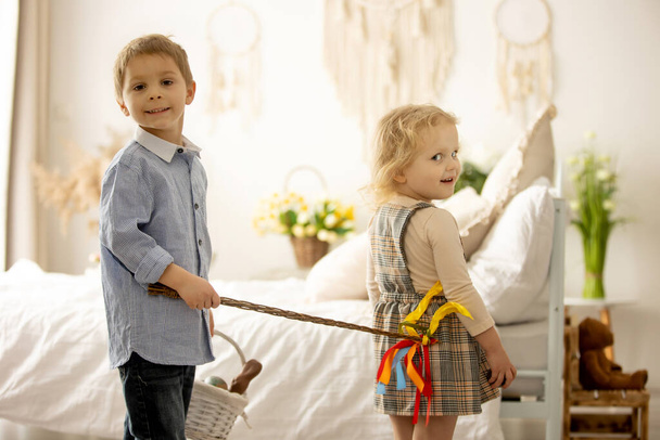 Happy children, siblings, enjoying Easter holiday together, tradition with handmade twig, braided whip made from pussy willow, traditional symbol of Czech Easter - Zdjęcie, obraz