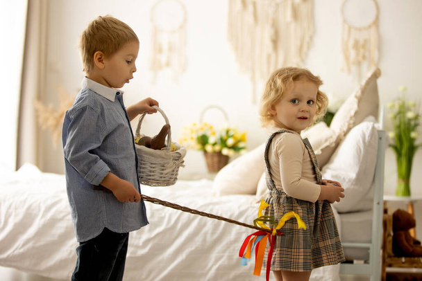 Happy children, siblings, enjoying Easter holiday together, tradition with handmade twig, braided whip made from pussy willow, traditional symbol of Czech Easter - Фото, изображение