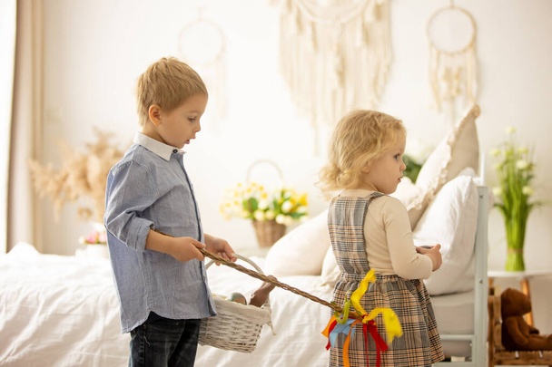 Happy children, siblings, enjoying Easter holiday together, tradition with handmade twig, braided whip made from pussy willow, traditional symbol of Czech Easter - Fotó, kép