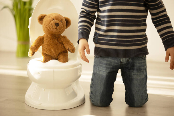 Little toddler child, boy,  pee in his pants while playing with toys, child distracted and forget to go to the toilet at home - Foto, immagini
