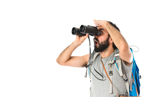 Backpacker with binoculars over isolated white background - Фото, изображение
