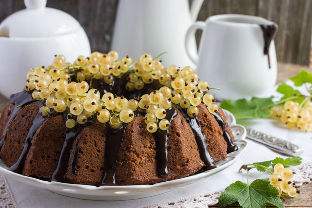Chocolate cake decorated chocolate glaze and white currant - Foto, Imagen