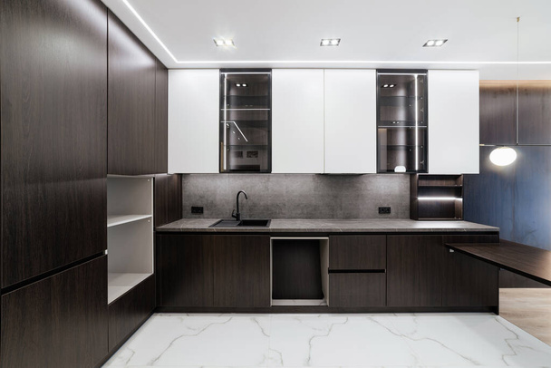 interiér nové kuchyně s tmavým nábytkem a světlými fasádami - Fotografie, Obrázek
