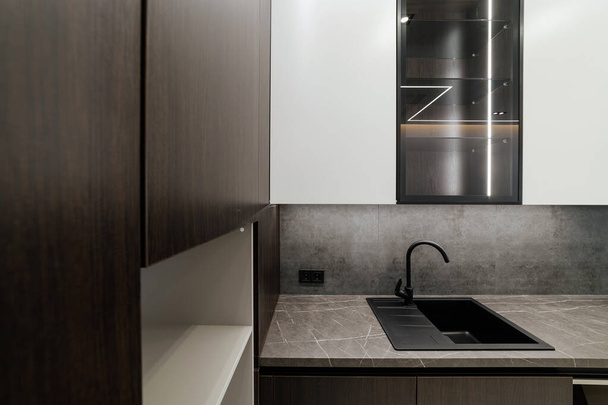 nová čistá kuchyň s černým dřezem kovové kohoutky a fasády - Fotografie, Obrázek