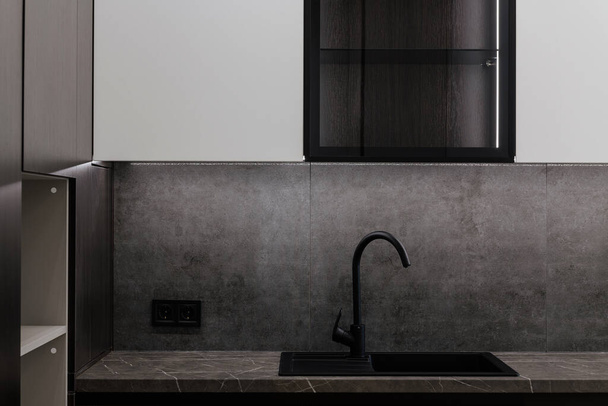 lavello nero controsoffitto grigio con rubinetto nero in metallo per l'acqua in cucina - Foto, immagini