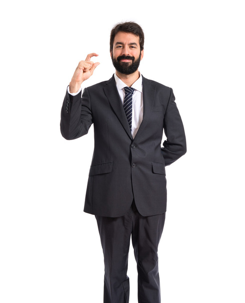 Businessman doing tiny sign over white background - Foto, afbeelding