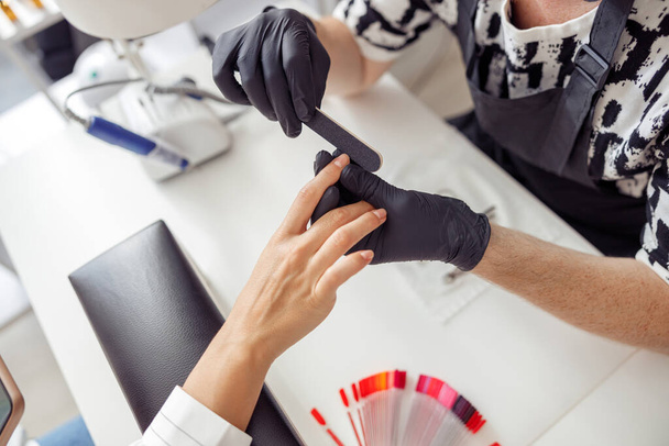 Nail technician doing professional manicure in beauty shop - Zdjęcie, obraz