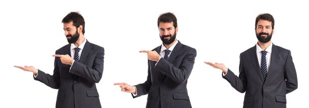Businessman pointing to the lateral over white background - Photo, Image