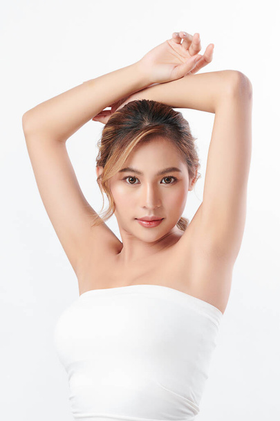 Beautiful Young Asian woman lifting hands up to show off clean and hygienic armpits or underarms on white background, Smooth armpit cleanliness and protection concept. - Photo, Image