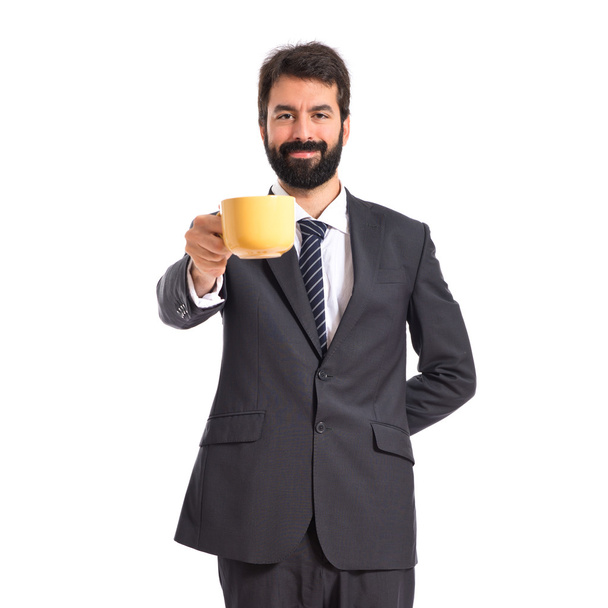 Üzletember gazdaság egy csésze kávét, mint fehér háttér - Fotó, kép