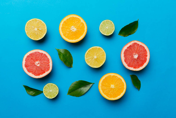 Плоская укладка цитрусовых фруктов, таких как лайм, апельсин и лимон с листьями лимонного дерева на светлом фоне. Пространство для текста. Вид сверху. - Фото, изображение