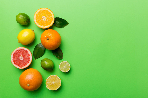 Fruit background. Colorful fresh fruits on colored table. Orange, lemon, grapefruit Space for text healthy concept. Flat lay, top view, copy space. - 写真・画像