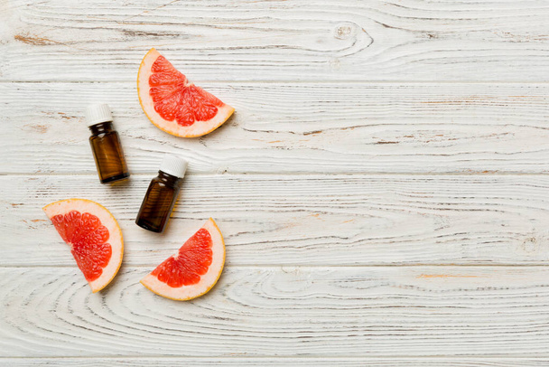 Bottles with Grapefruit fruit essential oil on wooden background. alternative medicine top view with copy space. - Fotografie, Obrázek