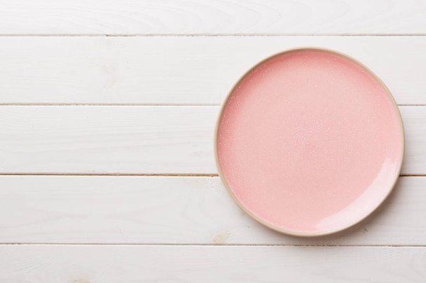 Top view of empty pink plate on wooden background. Empty space for your design. - Valokuva, kuva