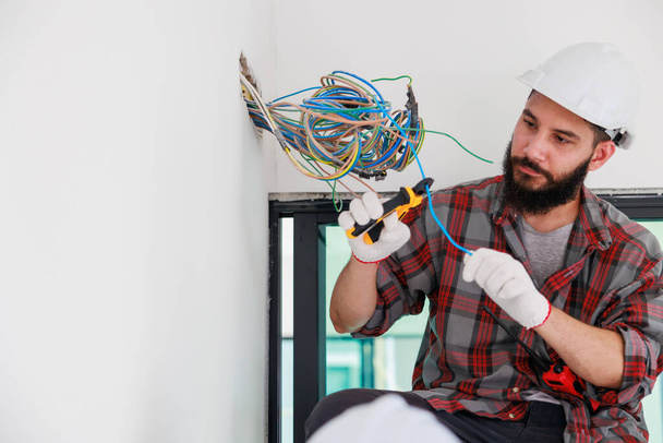 Spaanse mannelijke elektricien monteur installateur met een gereedschap in zijn handen. Onderhoudsdienst Reparatie en klusjesman concept - Foto, afbeelding
