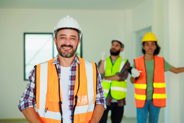 Портрет счастливый латиноамериканец строитель в защитном шлеме каска работает на строительной площадке.  - Фото, изображение