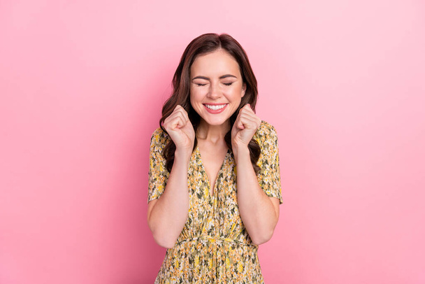 Photo of satisfied pretty lady closed eyes raise fists toothy smile isolated on shiny pink color background - Zdjęcie, obraz