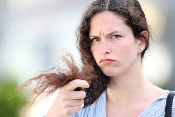 Angry woman with curly hair complaining about split ends in the street - Zdjęcie, obraz