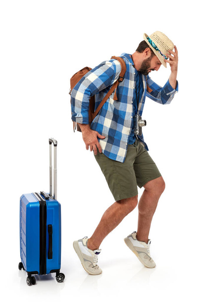 Cheerful man with summer clothing and luggage, white background - Foto, afbeelding