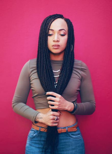 Be true to who you are. Shot of an attractive young woman with braids posing against a pink background. - Photo, Image