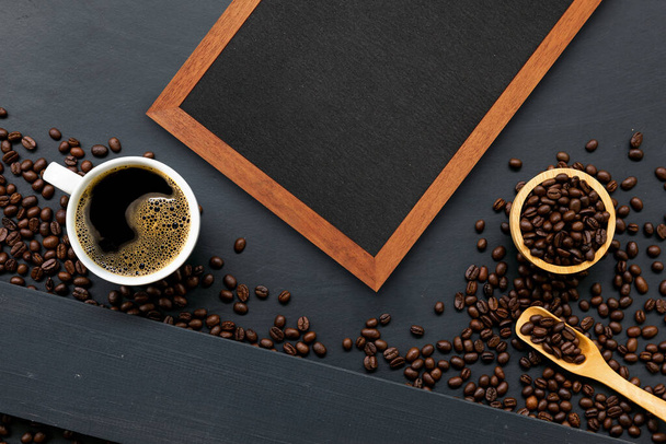 cup of coffee, wooden frame and bean on black wooden table background. top view. space for text. flay lay - Foto, Imagem