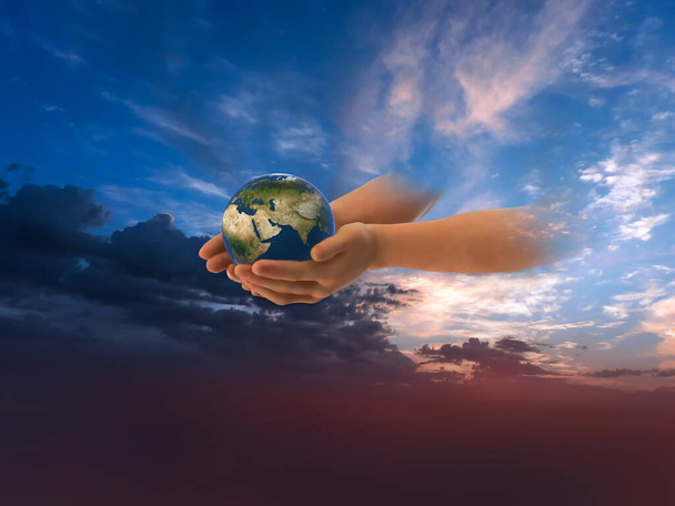eath globe w rękach na przedniej niebieskiej zachmurzone niebo trzymać pokojowe pojęcie natire tło  - Zdjęcie, obraz