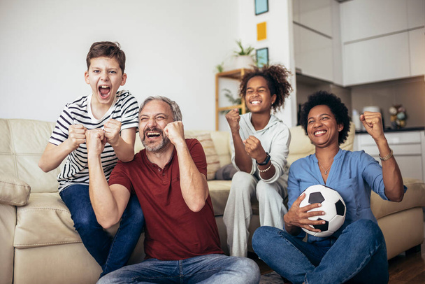 Podekscytowani fani piłki nożnej rodziny oglądanie sportu gra tv świętowanie cel razem - Zdjęcie, obraz