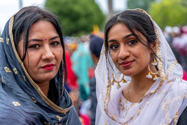 CREMONA, ITALY - APRIL 2022: young women of the Sikh monotheism religion in procession through the spring festival Vaisakhi in Cremona. The Sikh festival takes place every year. - Foto, Imagen
