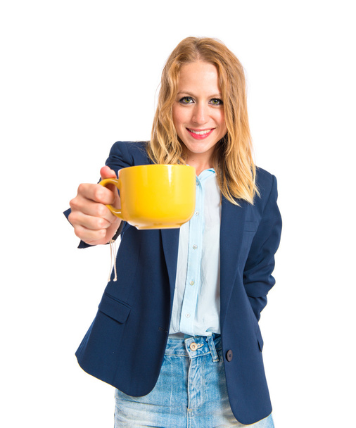 Blonde girl holding a cup of coffee over white background - Fotoğraf, Görsel