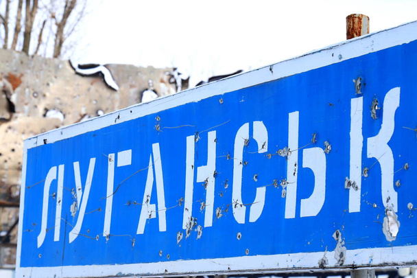  Road sign in Ukrainian - Lugansk, pierced by bullets, Ukrainian war in Donbass destruction, Ukraine  - Foto, Imagen