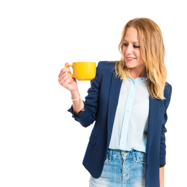 Menina loira segurando uma xícara de café sobre fundo branco
 - Foto, Imagem
