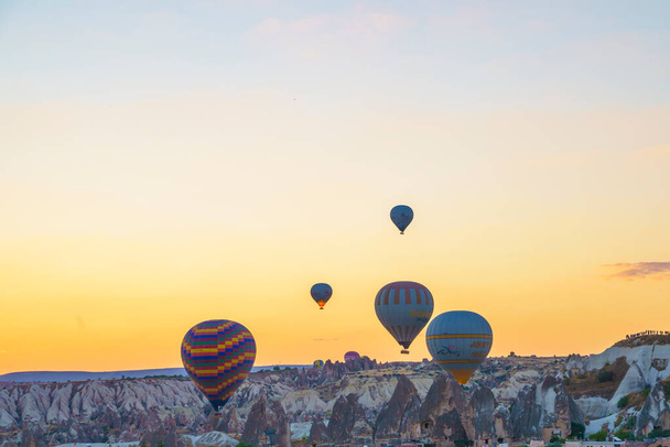 Set van kleurrijke ballonnen vliegen over Goreme stad in Cappadocië, tijdens zonsondergang op een heldere zomerdag, kopieer ruimte - Foto, afbeelding