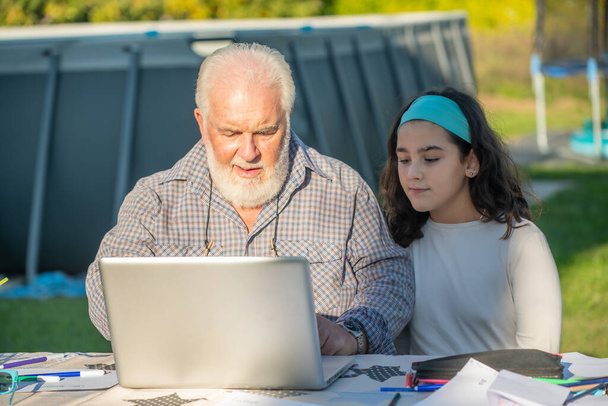 Nonno spiega come utilizzare il computer portatile a sua nipote - Foto, immagini