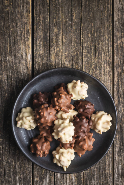 Chocolate truffles. Sweer pralines on plate on a wooden table. Top view. - Photo, Image